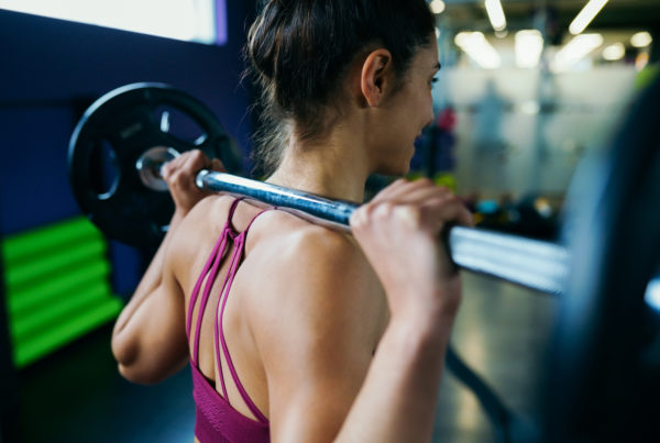 Athletic woman in gym lifting weights at the gym. Fitness goals.