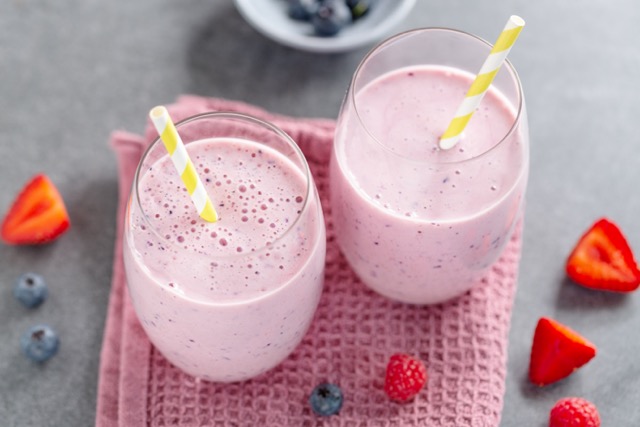 Fresh protein shake with berries oat and milk in glasses.